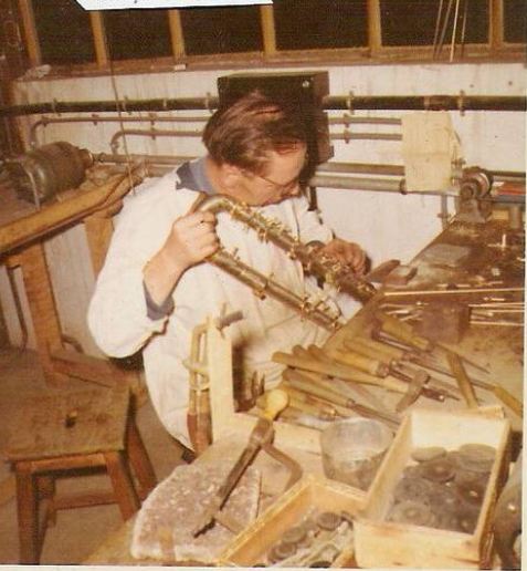 a craftsman is working on a contrabass clarinet.